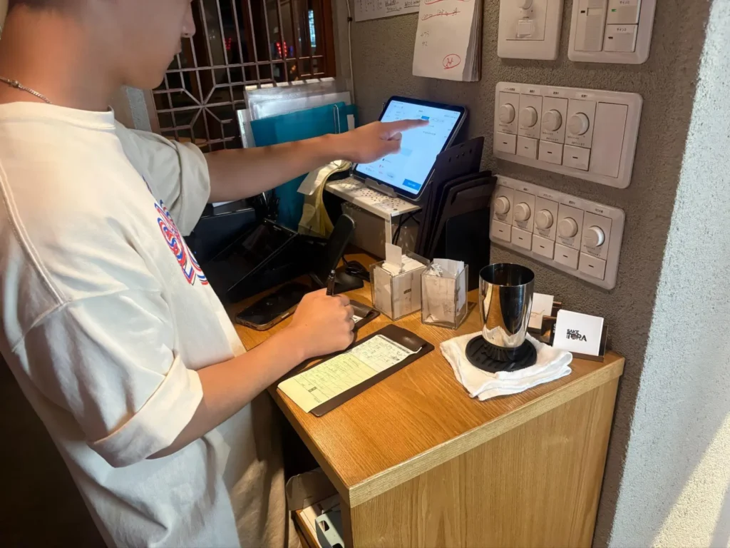 イザカヤ SAKETORAの会計カウンターでAirレジを操作している様子
